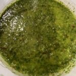 Picture of a cup filled with chimichurri sauce.