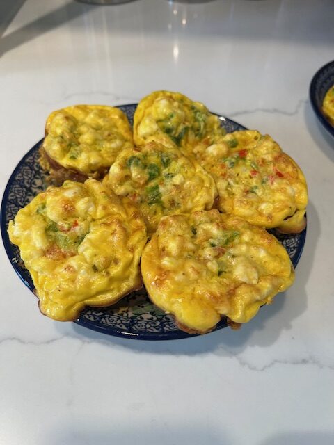 Picture of vegetable egg muffins on a blue plate on a white countertop.