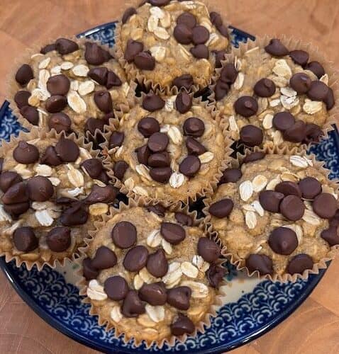 Picture of a plate of healthy oatmeal chocolate chip muffins on a blue and white plate.