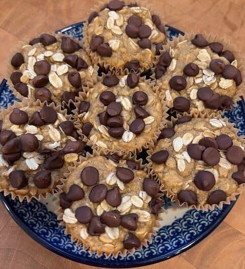 Picture of a plate of healthy oatmeal chocolate chip muffins on a blue and white plate.