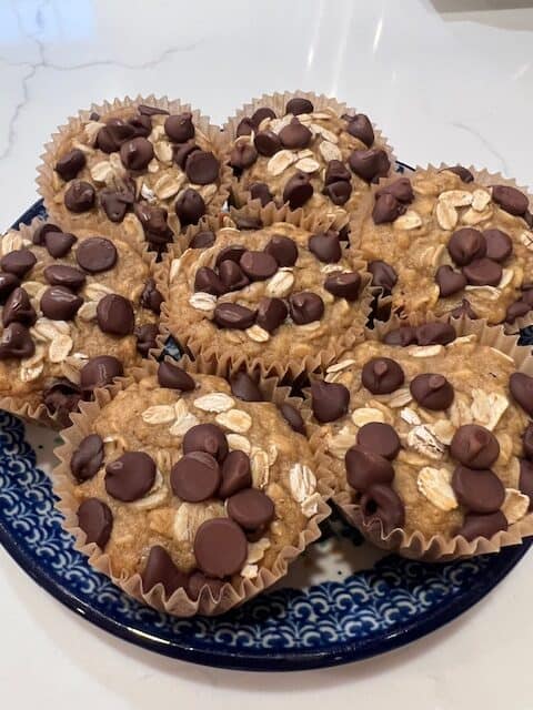 Picture of a plate of healthy oatmeal chocolate chip muffins on a blue and white plate.