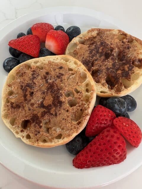 Picture of Honey Cinnamon Almond Butter Toast on a plate served with fresh strawberries and blueberries.