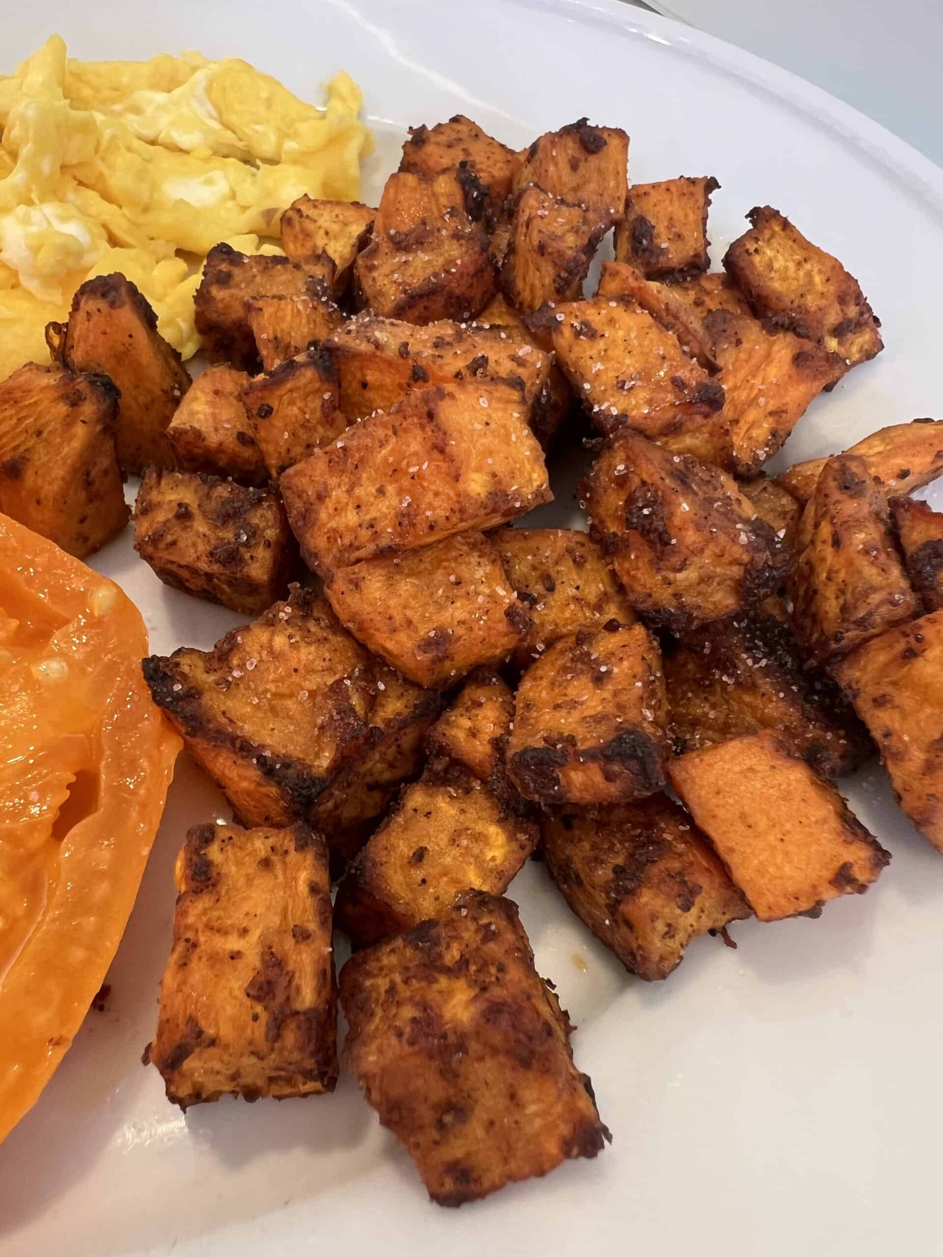 Picture of Lily's Spiced Sweet Potatoes on a plate paired with heirloom tomatoes and farm fresh eggs.